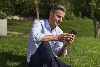 Man with phone on lawn